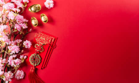 Chinese new year decorations made from red packet, orange and gold ingots or golden lump on a red background. Chinese characters FU in the article refer to fortune good luck, wealth, money flow.の写真素材