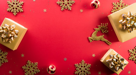 Christmas and new year background concept. Top view of Christmas gift box, reindeer, christmas ball and snowflake on red background.の写真素材