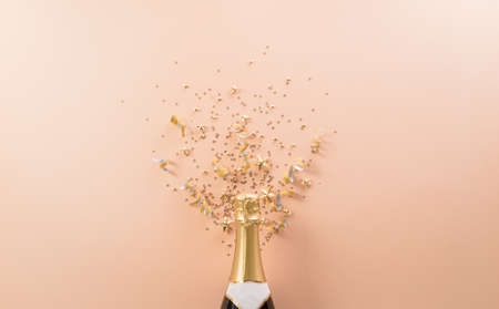 Happy New year celebration background concept. Champagne bottle with golden christmas ball and star on pastel background.の写真素材