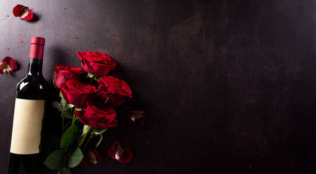 Love and Valentine's day concept made from red wine and rose on dark stone background. Top view with copy space, flat lay.の写真素材