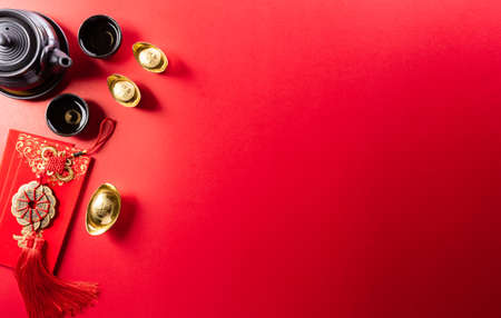 Chinese new year decorations made from red packet, orange and gold ingots or golden lump on a red background. Chinese characters FU in the article refer to fortune good luck, wealth, money flow.の写真素材