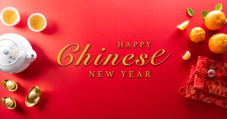 Chinese new year decorations made from red packet, orange and gold ingots or golden lump on a red background. Chinese characters FU in the article refer to fortune good luck, wealth, money flow.の写真素材