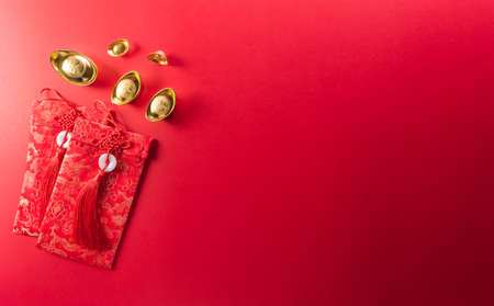 Chinese new year decorations made from red packet, orange and gold ingots or golden lump on a red background. Chinese characters FU in the article refer to fortune good luck, wealth, money flow.の写真素材