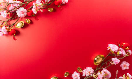Chinese new year decorations made from red packet, orange and gold ingots or golden lump on a red background. Chinese characters FU in the article refer to fortune good luck, wealth, money flow.の写真素材