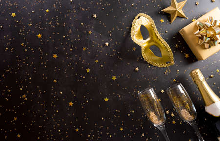 Happy Purim carnival decoration concept made from golden mask, wine, gift box and sparkle star on dark background. (Happy Purim in Hebrew, jewish holiday celebrate)の写真素材