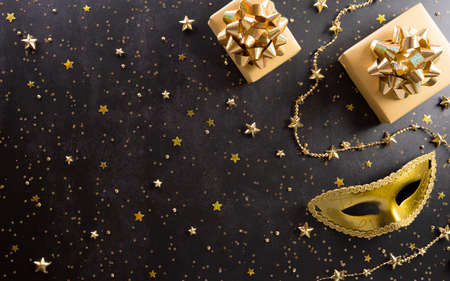 Happy Purim carnival decoration concept made from golden mask, wine, gift box and sparkle star on dark background. (Happy Purim in Hebrew, jewish holiday celebrate)の写真素材