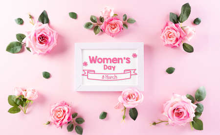 Happy Women's Day decoration concept. Top view of roses flower with picture frame and the text on pink pastel background.の写真素材
