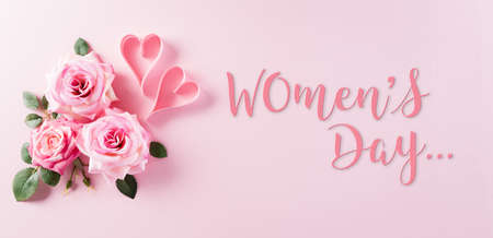 Happy Women's Day concept. Top view of roses flowers, heart and "Women's Day" text on pink pastel background.の写真素材