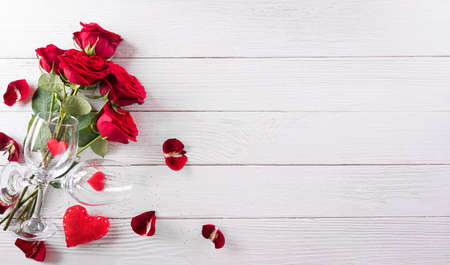 Love and Valentine's day concept made from champagne glasses , wine, red hearts and rose on white wooden background. Top view with copy space, flat lay.の写真素材