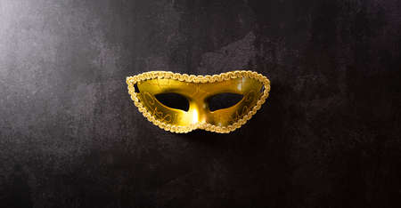 Happy Purim carnival decoration concept made from golden mask on dark background. (Happy Purim in Hebrew, jewish holiday celebrate)の写真素材