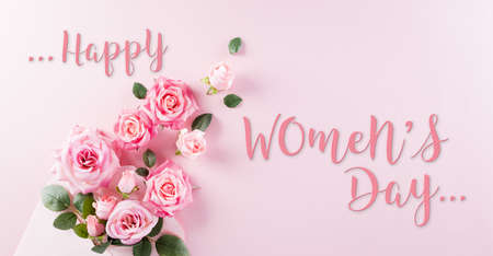 Happy Women's Day concept. Top view of roses flowers, heart and "Happy Women's Day" text on pink pastel background.の写真素材