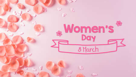 Happy Women's Day concept. Top view of roses flowers, heart and Women's Day text on pink pastel...