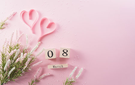 Happy Women's Day decoration concept made from flower, paper heart and wooden calendar on pink pastel background.の写真素材