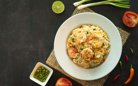 Asian fried rice with eggs, shrimp, vegetables and spice, closed up top view with space for text.の写真素材