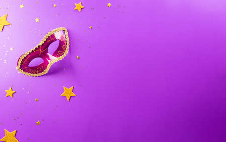 Happy Purim carnival decoration concept made from mask and sparkle star on purple background. (Happy Purim in Hebrew, jewish holiday celebrate)の写真素材