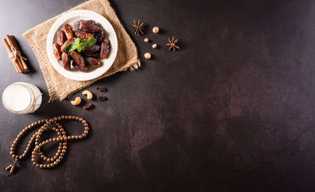 Ramadan Kareem background concept, Rosary bead with dates fruit and milk on dark stone background.の写真素材