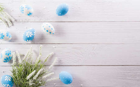 Happy easter! colourful Easter eggs and flower on white wooden background.の写真素材