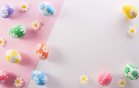 Happy easter decoration concept. Colourful Easter eggs with flowers on pink and white background.の写真素材