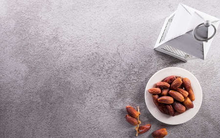 Top view image of Ramadan Kareem decoration, dates fruit, tea and rosary beads on dark stone background.の写真素材
