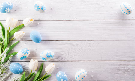 Happy easter! colourful Easter eggs and flower on white wooden background.の写真素材
