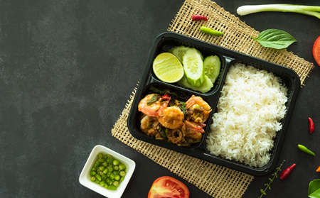 Top view of stir fried basil with shrimp, a famous Thai street food served in box for delivery food concept.の写真素材