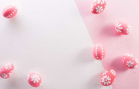 Happy easter decoration concept. Colourful Easter eggs with flowers on pink and white background.の写真素材