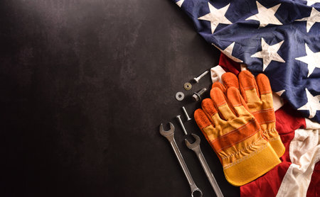 Happy Labor day concept. American flag with different construction tools on dark stone background.の写真素材