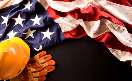 Happy Labor day concept. American flag with different construction tools on dark stone background.の写真素材