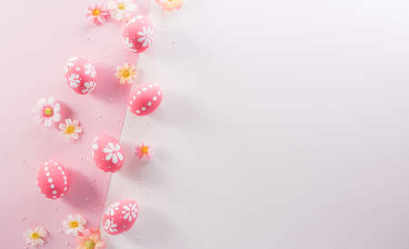 Happy easter decoration concept. Colourful Easter eggs with flowers on pink and white background.の写真素材