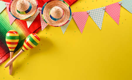Cinco de Mayo holiday background made from maracas, mexican blanket stripes or poncho serape and hat on yellow background.の写真素材