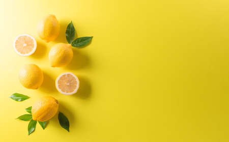 Summer composition made from oranges, lemon or lime on pastel yellow background. Fruit minimal concept. Flat lay, top view, copy space.の写真素材