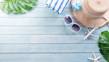 Summer composition concept made from starfish, beach hat, flip flop, airplane,medical mask and monstera leaf on pastel blue background.  Summer travel during  disease concept.の写真素材