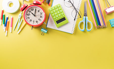 Education or back to school Concept. Top view of Colorful school supplies with books, color pencils, calculator, pen cutter clips and apple on pastel paper background.の写真素材