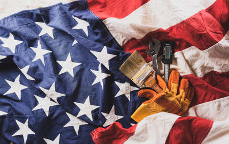 Happy Labor day concept. American flag with different construction tools on dark wooden background.の写真素材