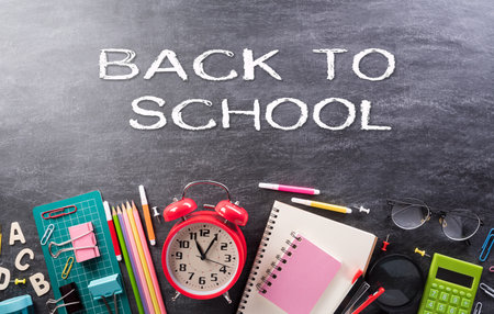 Education or back to school Concept. Top view of Colorful school supplies with books, color pencils, calculator, pen, cutter and clips on backboard background.の写真素材