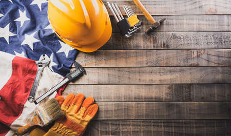 Happy Labor day concept. American flag with different construction tools on dark wooden background.の写真素材