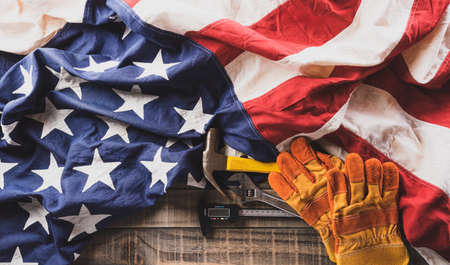 Happy Labor day concept. American flag with different construction tools on dark wooden background.の写真素材