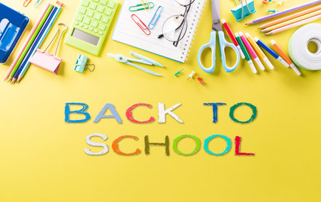 Education or back to school Concept. Top view of Colorful school supplies with books, color pencils, calculator, pen cutter clips and apple on pastel paper background.の写真素材