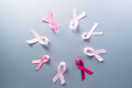Pink ribbon on pastel paper background for supporting breast cancer awareness month campaign.の写真素材