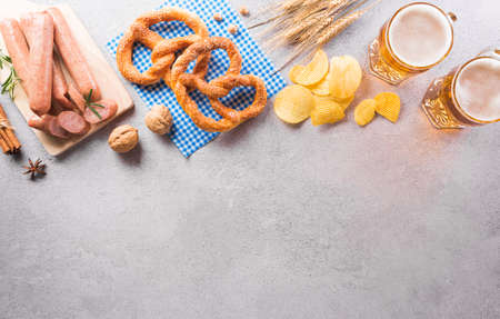 festival decoration symbols made from Pretzel loaf, beer, sausage, potato chips and Bavarian white and blue fabric on stone background.の写真素材