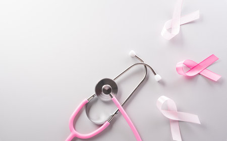 Pink ribbon and stethoscope on paper background for supporting breast cancer awareness month campaign.の写真素材