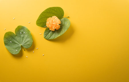 Happy Dussehra. Yellow flowers, green leaf and rice on yellow paper background. Dussehra Indian Festival concept.の写真素材