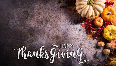 Thanksgiving background concept with fall leaves, pumpkin and seasonal autumnal decor and the text on dark stone background.の写真素材