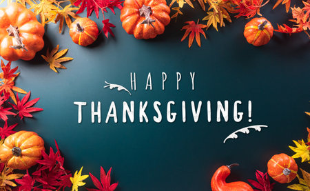 Autumn and thanksgiving decoration concept made from autumn leaves and pumpkin on dark background. Flat lay, top view with copy space.の写真素材