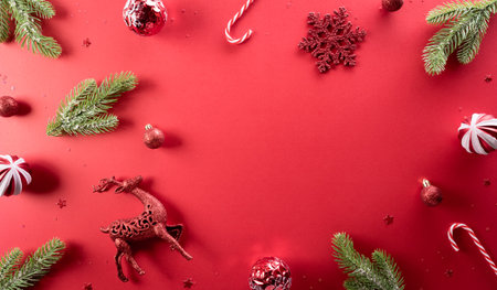 Christmas and new year background concept. Top view of Christmas decoration made from snowflake, christmas ball and  pine branches on red background.の写真素材