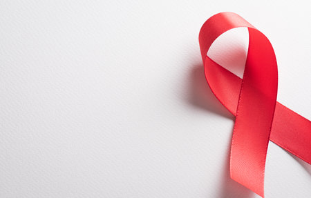 Closeup red ribbon HIV, world AIDS day awareness ribbon on white background. Healthcare and medicine concept.の写真素材