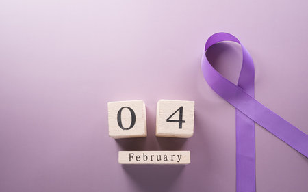 Purple ribbon and wooden calendar on pastel paper background for supporting World Cancer Day campaign on February 4.の写真素材