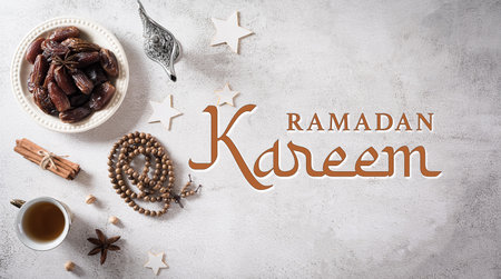 Ramadan food and drinks concept. Ramadan arabian lamp, wood rosary, tea, and dates fruit on stone background.の写真素材