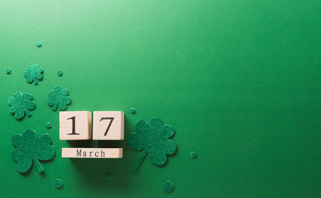 Happy St Patrick's Day decoration concept made from shamrocks ( clover leaf), wooden calendar and leprechaun hat on green background.の写真素材