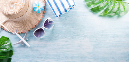 Summer composition concept made from starfish, beach hat, flip flop, airplane,medical mask and monstera leaf on pastel blue background.の写真素材